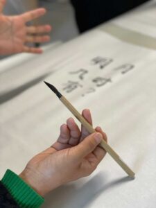 Workshop participants drawing with a caligraphy brush.