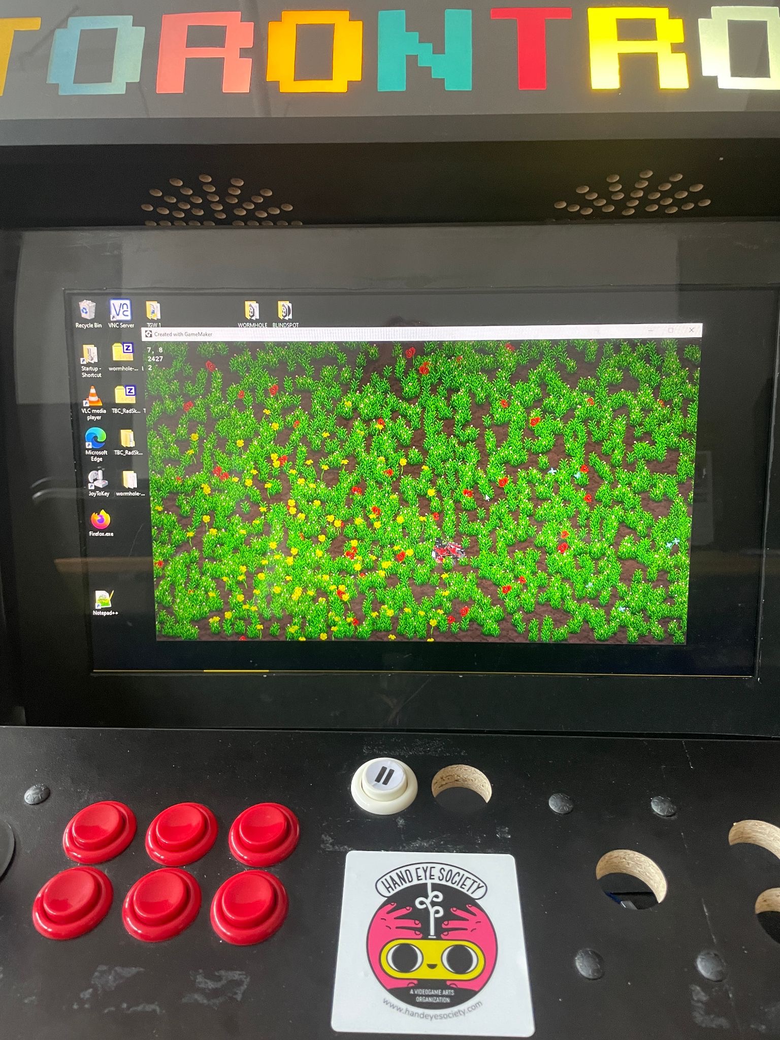 Torontron arcade cabinet with red buttons, joystick and a game running on the screen.